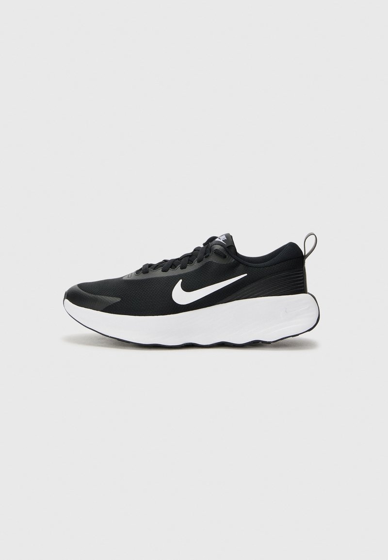 Chaussure de course Nike noire et blanche avec une semelle blanche épaisse, une tige en mesh noire, un logo Nike swoosh blanc et une languette de talon rembourrée.