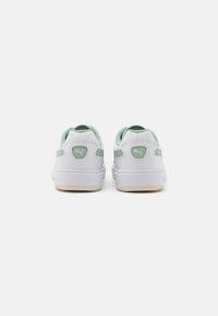 Vita och mintgröna sneakers med en slät läderytan, vadderad krage, gummisula och en logotyp på hälen.