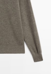 Gerippter Strickpullover in Olivgrün mit langen Ärmeln und rundem Halsausschnitt. Der Stoff ist weich und hat eine strukturierte Optik.