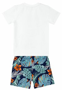 Setti sisältää valkoisen lyhythihaisen T-paidan ja tummansiniset shortsit, joissa on trooppinen lehti- ja kukkakuosi vihreänä, oranssina ja sinisenä.