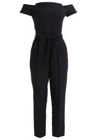 Svart jumpsuit med avtagna ärmar, figurnära midja och bälte. Har avsmalnande ben med ett slätt, texturerat tyg.