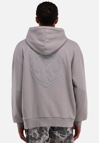 Grau Hoodie mit lockerer Passform, ausgestattet mit einem großen blauen Logo, das auf den Rücken gestickt ist. Gerippte Bündchen und Saum sorgen für Textur. Weicher Stoff.