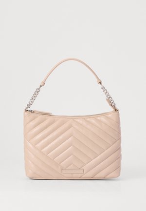 Gequilte beige leren handtas met een gebogen handvat, zilveren kettingdetail en ritssluiting, met een chevronpatroon en een rechthoekig logo patch.