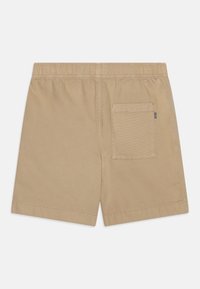 Shorts en coton beige avec une taille élastique, dotés d'une seule poche arrière et de détails cousus. Texture douce et coupe décontractée.