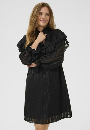 Abito nero con scollo arricciato e maniche lunghe trasparenti. Tessuto testurizzato con righe verticali. Design lungo fino al ginocchio con vestibilità ampia.
