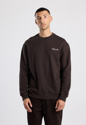 Bruine sweatshirt met een ronde hals en lange mouwen. Bevat subtiele borduursels op de borst. Stoere textuur, ontspannen pasvorm.