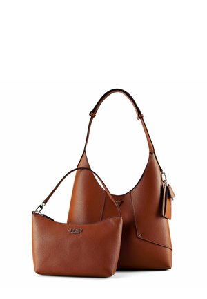 Twee bruine leren GUESS handtassen, een kleine schoudertas en een grotere tote met een hanglabel, beide met een korrelige structuur.