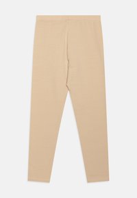 Beige leggings, puha, rugalmasságot biztosító anyagból. Fitted dizájn jellemzi őket, rugalmas derékpánttal rendelkeznek, és nincsenek látható varrásaik vagy mintáik.