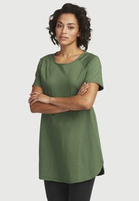 Grøn, kortærmet tunika lavet af bl�ødt bomuld med en rund halsudskæring og let buet kant, stylet med sorte leggins.