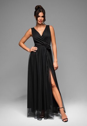 Robe maxi noire avec un design enveloppant, décolleté en V et fente sur le côté. Présente une jupe texturée et un accent floral à la taille.