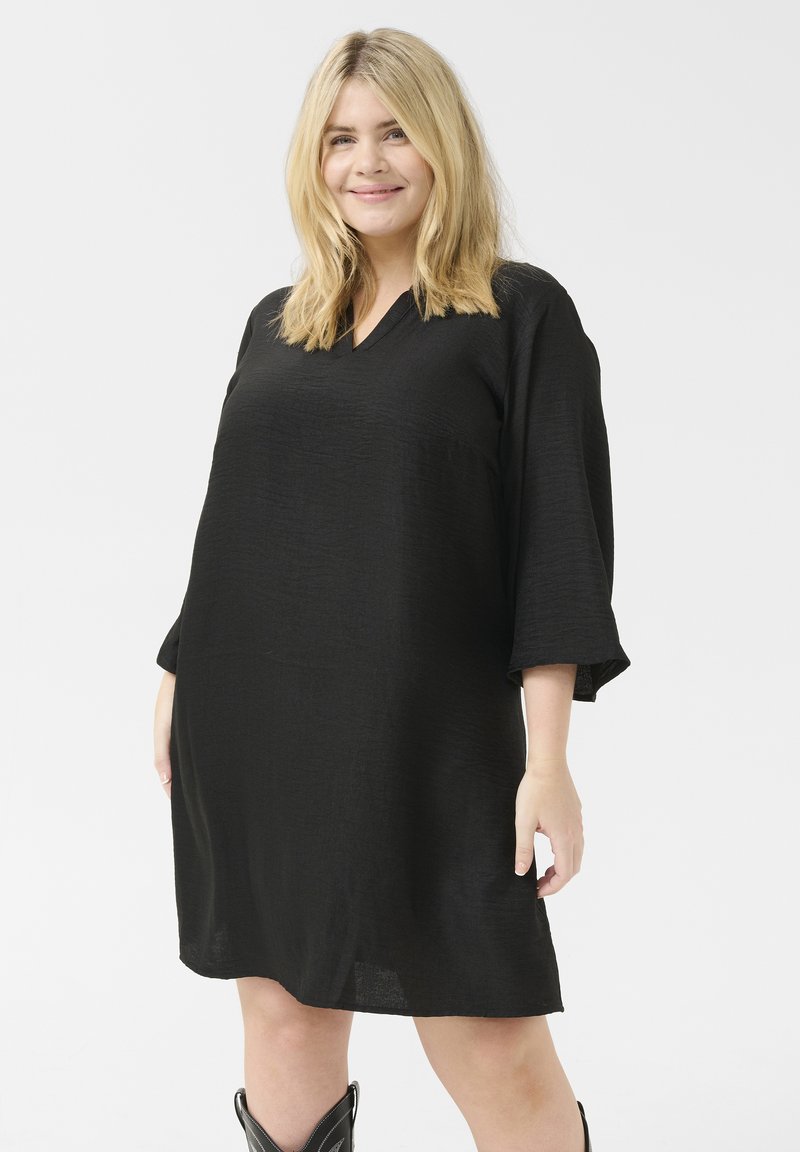 Robe noire avec un décolleté en V et des manches trois-quarts, en tissu texturé, présentant une coupe décontractée et une longueur jusqu'aux genoux.