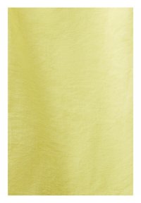 Texture de tissu jaune doux avec un motif de tissage subtil et une légère ombre sur la surface.
