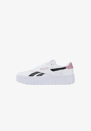 Sneaker bianca Reebok con strisce laterali nere, dettaglio rosa sul tallone e suola spessa bianca vista dal lato esterno.