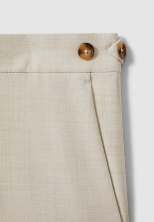 Beige stoffen broek met een gestructureerde afwerking, voorzien van twee bruine knopen in de tailleband en een subtiel plooi-detail.