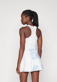 Brezrokaven obleka s prilagojenim zgornjim delom in razširjenim krilom, ki ima modro in belo akvarelno vzorčje, izdelana iz elastičnega materiala.