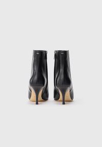 Black leather ankle boots with a smooth texture, featuring a pointed toe and a high stiletto heel. Includes a rear zip closure.