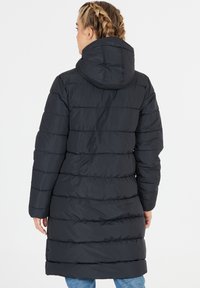Musta puhvitakki hupulla, jossa on tilkkutäkki-tyylinen muotoilu ja vaakasaumat. Kangas näyttää olevan sileä ja eristetty.