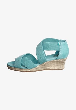 Sandales compensées turquoise avec un design à brides croisées ; tige en tissu, semelle intermédiaire en jute espadrille et semelle extérieure en caoutchouc plate.