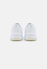 Białe sneakersy z gładką skórzaną cholewką, teksturowanymi akcentami, wyściełanym kołnierzem i masywną podeszwą z lekkim wzorem bieżnika z gumy.