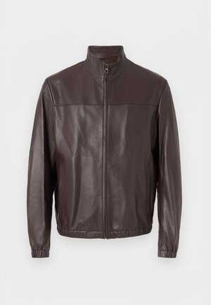 Καφέ δερμάτινο μπουφάν με γιακά τύπου stand, εμπρόσθιο φερμουάρ, ελαστικές μανσέτες και τελείωμα, σε απλό λευκό φόντο.