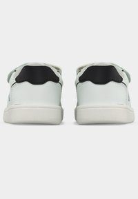 Άσπρα αθλητικά παπούτσια με λείο φινίρισμα, μαύρες λεπτομέρειες στη φτέρνα και στον γιακά, και γκρι υφασμένο γλώσσα με θηλιά για εύκολη εφαρμογή.