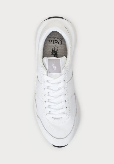 Λευκό αθλητικό παπούτσι με υφασμάτινο συνθετικό πάνω μέρος, κλείσιμο με κορδόνια, μαξιλαρωμένο κολάρο και αντίθετη σκούρα σόλα. Λογότυπο στη γλώσσα.