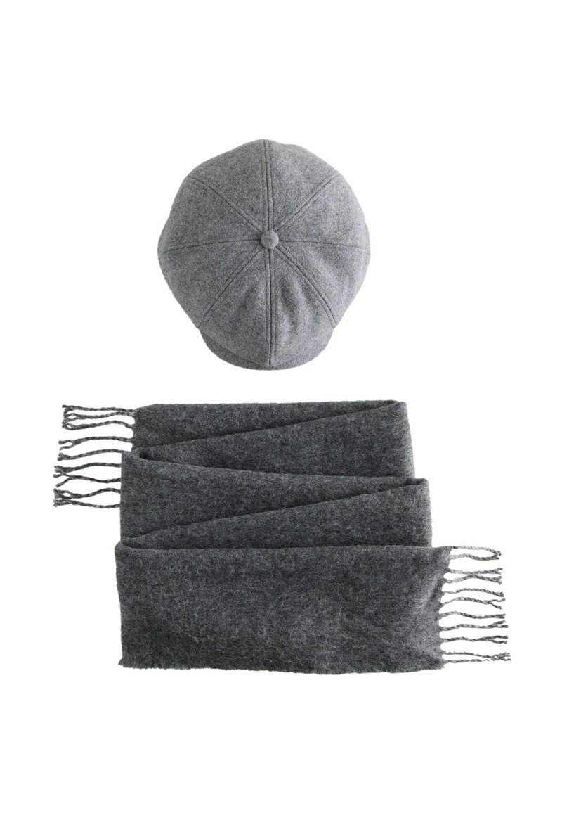 Szara wełniana czapka z ośmioma panelami i guzikiem na górze, w połączeniu z długim szarym szalikiem z frędzlami. Miękka tekstura, jednolity kolor.