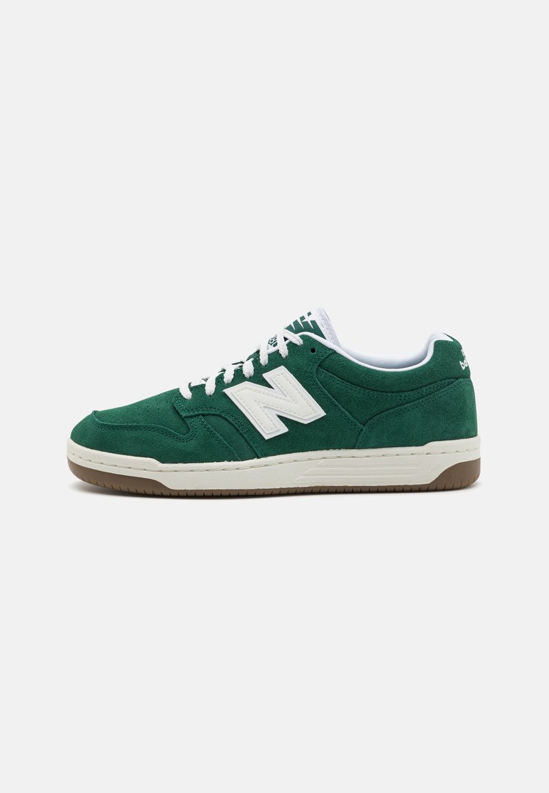 Green suede sneakers with white accents, round laces, and a gum sole. Features a prominent white "N" logo on the side. Low-top design.