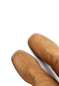 Kergelt tan suede ankle-kingad, millel on sile ja tekstuuriga pind. Ümar varvas ning õmmeldud detailid äärel. Lihtne, minimalistlik disain.