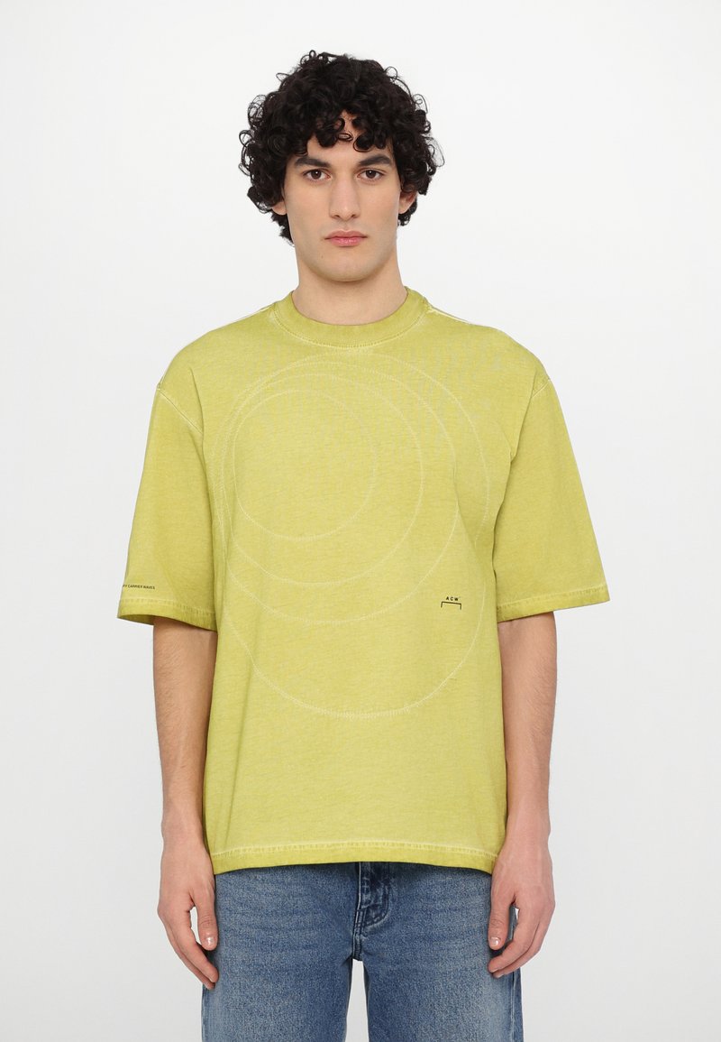 Short-sleeve, lime green t-shirt made of soft fabric featuring circular stitching details and subtle branding on the left sleeve.