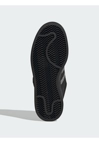 Crni đon obuće s teksturiranim valovitim uzorkom. Ima glatki rub, blagi zavoj i grafički dizajn sa strane.