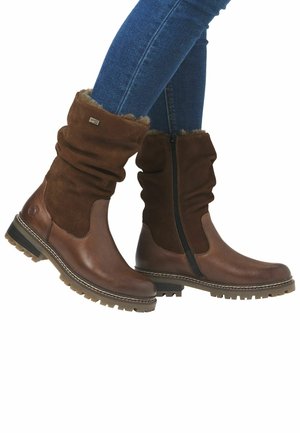 Bottines marron décontractées à la cheville avec un design en cuir et daim mélangé, ornées d'une bordure en fausse fourrure, d'une fermeture éclair sur le côté et d'une semelle en caoutchouc robuste.