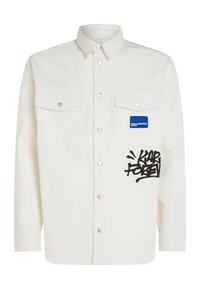 Camicia di jeans bianca con maniche lunghe, bottoni a pressione, due tasche sul petto, logo in patch blu e testo in stile graffiti nero sulla parte anteriore.