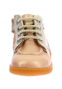 Botín de cuero en melocotón claro y plata, con cordones trenzados, una cremallera lateral y una suela de goma texturizada.