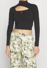 Svart långärmad crop top med hög krage, med en framskärning och liten orange logotypdetalj. Mjuk, stretchig tygkvalitet med en figurnära design.