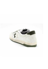 Basket en cuir blanc avec des accents verts olive, dotée d'un talon texturé, de lacets noirs et d'une semelle de couleur crème avec des marques d'usure. Détail en forme d'étoile sur le côté.