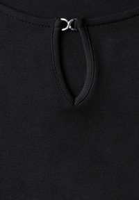 Musta kangas ylhäällä, jossa on pieni avainreikälahja hopeisella metallisoljella. Sujuva rakenne ja yksinkertainen muotoilu.