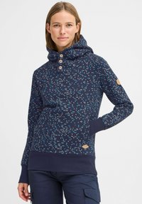 Mörkblå hoodie med flerfärgat prickmönster, med hög krage, tre träknappar, ribbade ärmslut och en sidoficka.