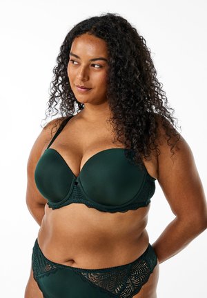 Dark green padded bra with lace trim, underwired design, and adjustable straps. Smooth texture with a decorative lace pattern at the base.