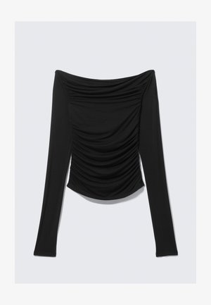 Melns garām piedurknēm, plecus atsegts tops ar rušētiem akcentiem priekšpusē un piegulošu siluetu uz vienkārša fona.