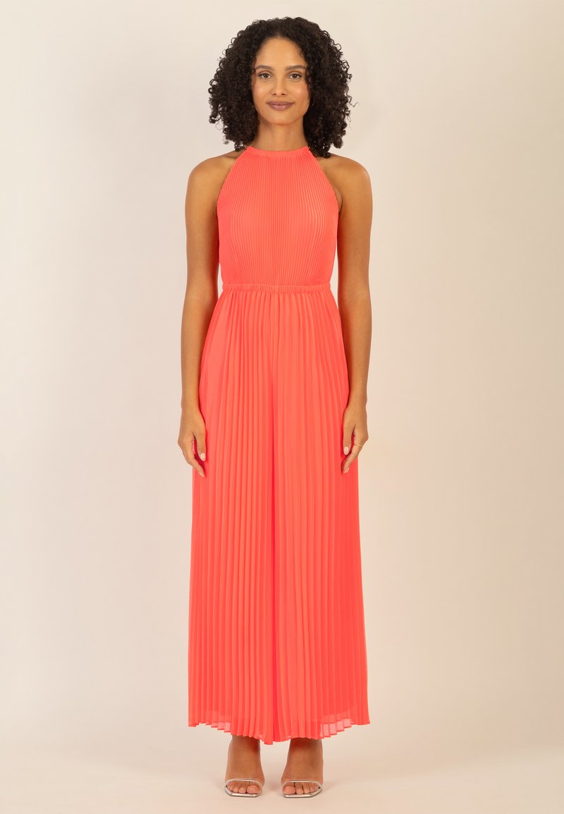 Vestido de largo hasta el suelo con cuello halter en un brillante color coral, con plisado vertical. La tela parece ligera y tiene una textura suave; presenta un corsé ajustado.