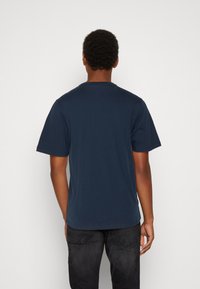 Navy blue cotton t-shirt with short sleeves, round neck, and a relaxed fit. Back view shows smooth texture and no visible graphics or labels.