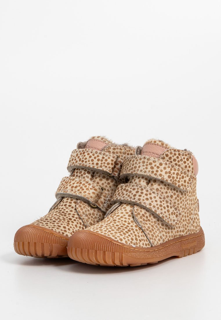 Tanfarbene Kleinkinderschuhe mit braunen Punkten, doppelten Klettverschlüssen und strukturierten Gummisohlen für besseren Halt.