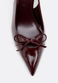 Chaussure plate à bout pointu en cuir verni bordeaux avec un détail de nœud à l'avant et la taille 37 indiquée à l'intérieur.