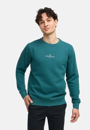 Sudadera en color azul verdoso con cuello redondo, puños y dobladillo de canalé. Presenta un texto de logo en blanco, fabricada con una tela suave y de textura lisa.