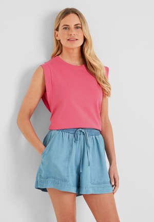 Pink sleeveless top with a round neckline paired with light blue denim shorts featuring an elastic waistband and pockets.