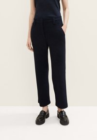 Navy wolmix straight-leg pantalons met opgestikte zakken, riemlussen en een gladde textuur; gecombineerd met zwarte instappers.