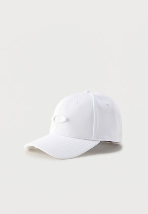 Gorra de béisbol blanca con visera curva y pequeño logo ovalado en la parte delantera, mostrada sobre un fondo claro.