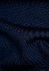 Marineblau gestrickter Stoff mit glatter Textur und feinem Rippmuster, das subtile Farbvariationen und ein gleichmäßiges Stitchmuster zeigt.