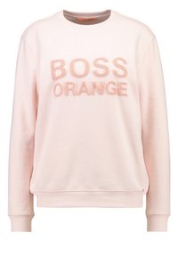 Sudadera de color rosa claro con cuello redondo, puños y dobladillo de canalé. Presenta texto bordado en felpa levantada "BOSS ORANGE" en melocotón claro.